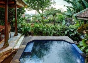 una piscina en medio de un jardín en Tirtagangga Water Palace Villas, en Tirtagangga