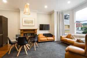 uma sala de estar com um sofá e uma mesa em The Stuart Street Terraced House em Dunedin