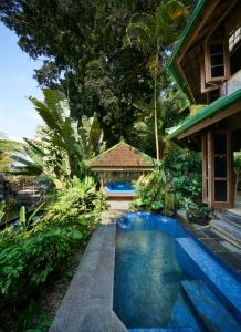 a house with a swimming pool in front of a house at Tirtagangga Water Palace Villas in Tirtagangga