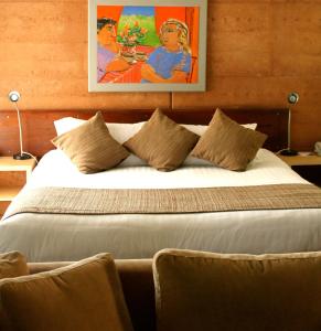 um quarto com uma cama grande e uma pintura na parede em The Pemberton Hotel em Pemberton