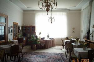 uma sala de jantar com mesas e cadeiras e um lustre em Haus-Maria em Bad Salzschlirf