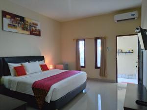 a bedroom with a large bed and a bathroom at Beji Ayu Homestay in Seminyak