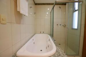 eine weiße Badewanne in einem Badezimmer mit Dusche in der Unterkunft Hotel Maione in Goiânia