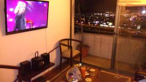 a room with a large window with a tv on the wall at Frente al parque (Solo mujeres) in Santiago