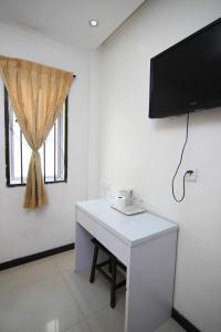 a room with a white desk with a tv on the wall at Rose Cottage Hotel Bandar Seri Alam in Masai