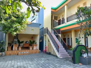 a courtyard of a house with a staircase at Beji Ayu Homestay in Seminyak