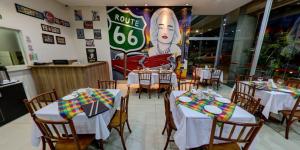 a restaurant with tables and chairs and a sign that reads route at Hotel Maione in Goiânia