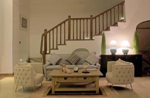 a living room with a couch and two chairs at Era Beach in Unawatuna