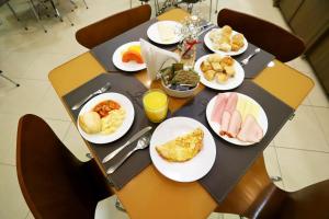 ein Tisch mit Tellern mit Frühstücksspeisen in der Unterkunft Hotel Maione in Goiânia