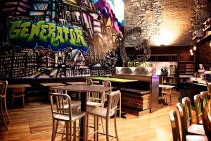 un restaurante con mesas y sillas y una pared con graffiti en Generator Dublin, en Dublín