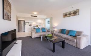 a living room with two couches and a table at Ocean Pacific Resort - Official in Gold Coast