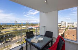 a balcony with a table and chairs and a large window at Ocean Pacific Resort - Official in Gold Coast