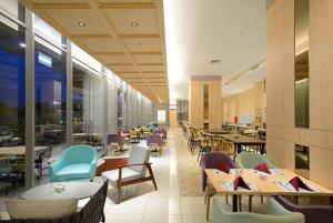 a dining room with tables and chairs and a cafeteria at Midtown Residence Surabaya in Surabaya