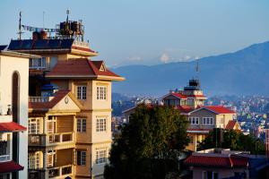 um grupo de edifícios com montanhas ao fundo em Bodhi Guest House em Baudhatinchule