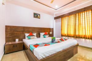 a bedroom with a large bed and a window at Yashaswi Comforts in Mysore