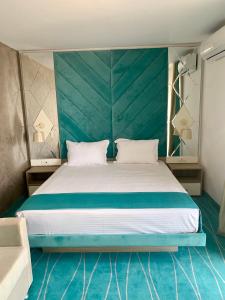 a bedroom with a large bed with a green headboard at Hotel Meteor in Jupiter