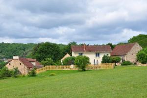 a group of houses in a field with a fence at gîtes les 7 roches 6 couchages in Les Eyzies-de-Tayac