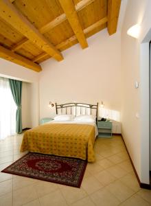 um quarto com uma cama com uma colcha amarela em Agriturismo Biologico Corte Aragonese em Santa Maria di Licodia