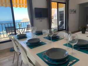 a dining table with wine glasses and a view of the ocean at Casa Hana in Mogán
