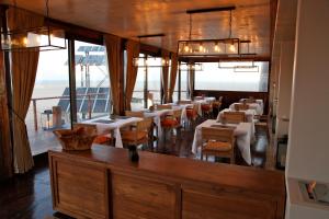 uma sala de jantar com mesas, cadeiras e janelas em Pelican Point Lodge em Walvis Bay