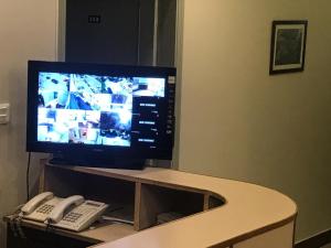 a television sitting on top of a table with a phone at Jasmine Inn in Islamabad