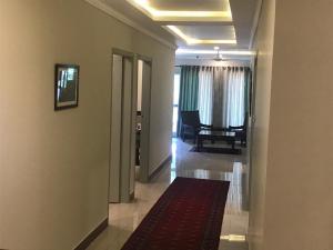 a hallway with a hallway leading to a room with a carpet at Jasmine Inn in Islamabad