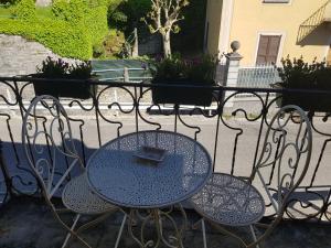 Faggeto Lario にあるLe Finestre sul Lagoのテーブルと椅子(フェンス付きのパティオあり)