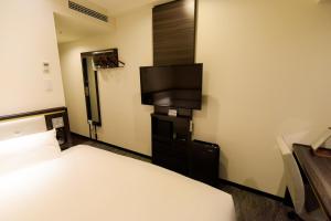 a hotel room with a bed and a flat screen tv at Via Inn Nagoya Station Tsubaki-cho in Nagoya
