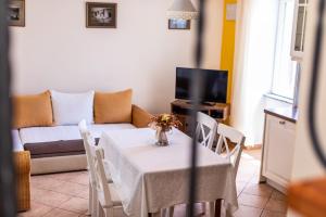 a living room with a table and a couch at Apartments Riva in Baška
