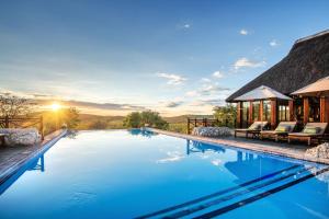 a pool with a view of a house at Epacha Game Lodge & Spa in Okaukuejo +34 photos