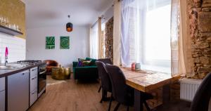 Apartmán Luxury - Veľký Slavkov في فلكي سلافكوف: مطبخ وغرفة طعام مع طاولة وكراسي خشبية