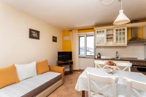 a living room with a couch and a table at Apartments Riva in Baška