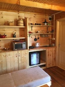 a kitchen with wooden cabinets and a tv in it at Cozy Cabin in Žabljak