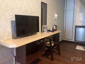 a desk with a television on it in a room at Flower Motel in Chiayi City