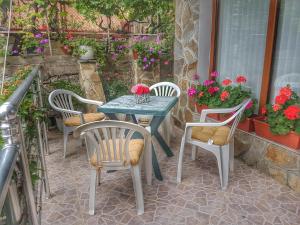 a table and chairs on a patio with flowers at Guest House Byki in Sveti Vlas