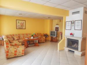a waiting room with couches and a tv and a fireplace at Guest House Byki in Sveti Vlas