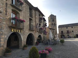 a building with a hotel sign on the side of it at Los Arcos in Aínsa