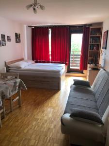 1 dormitorio con cama, sofá y ventana en Retro apartments Kaninska vas en Bovec