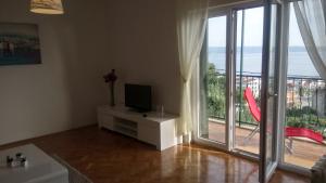 a living room with a tv and a large window at Apartmani AMI in Podstrana