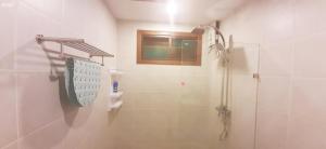 a bathroom with a shower and a toilet and a sink at Khanom Beach Residence in Khanom