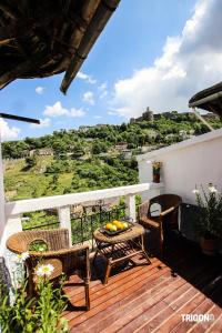 a patio with a table and chairs on a balcony at Trigona Hostel in Gjirokastër