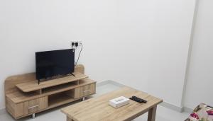a living room with a tv on a wooden table at Duqm Suites in Duqm