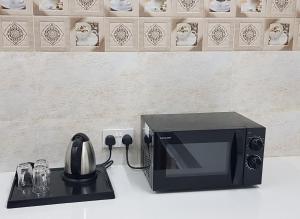 a microwave oven sitting on top of a counter at Duqm Suites in Duqm