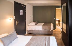1 dormitorio con 2 camas y puerta a una habitación en Le Comte Rouge, en Thonon-les-Bains