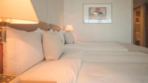 two beds in a hotel room with white pillows at Grandvrio Resort Saipan in Garapan