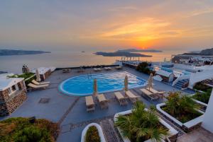 an aerial view of a resort with a pool and the ocean at Caldera Butterfly Villas in Fira