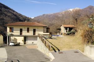 ein Haus mit einer Auffahrt vor einem Berg in der Unterkunft Agriturismo Runchee in Vercana