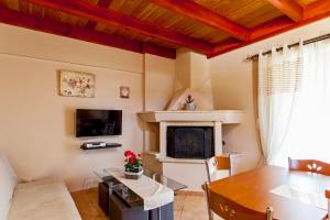 uma sala de estar com uma mesa e uma lareira em Estate Kares em Tílisos