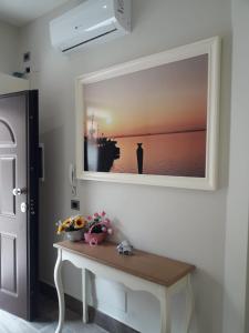 um quarto com uma mesa com uma fotografia na parede em veronica's b&b em Lesina