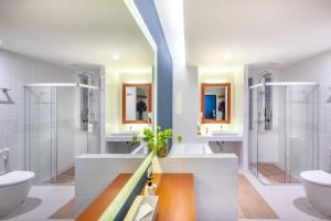 合艾的住宿－Monkham Village Hat Yai，一间带两个盥洗盆、淋浴和卫生间的浴室